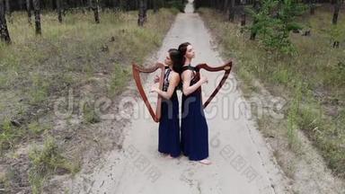 两个女竖琴手站在森林路上弹琴。
